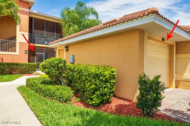 13751 Julias Way Unit 414, Fort Myers, FL 33919 - view of home's exterior with stucco siding, an attached garage, and a tile roof