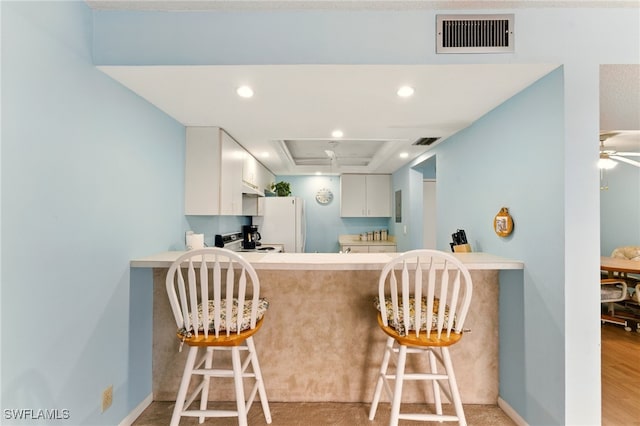 3460 N Key Dr Unit 409, North Fort Myers, FL 33903 - kitchen with freestanding refrigerator, a peninsula, stove, a raised ceiling, and a kitchen breakfast bar