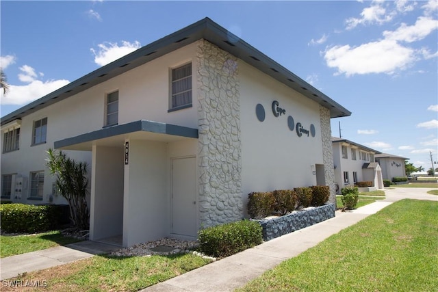 4014 Coronado Pkwy Unit 106, Cape Coral, FL 33904 - view of front of house featuring stucco siding and a front lawn