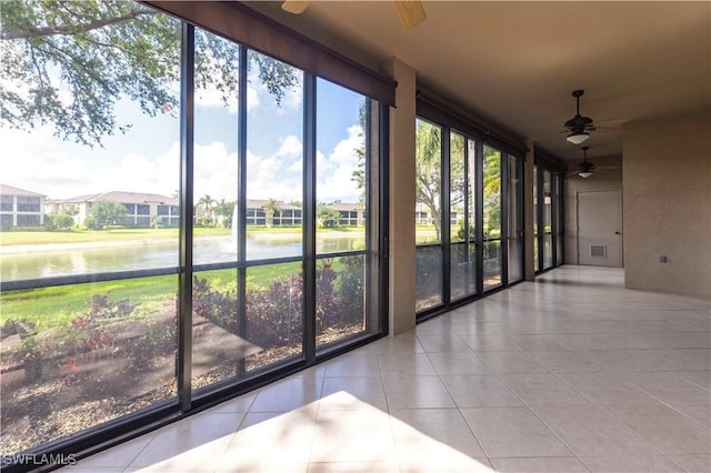 793 Regency Reserve Cir Unit 4501, Naples, FL 34119 - unfurnished sunroom featuring ceiling fan, a water view, tile patterned flooring, and expansive windows