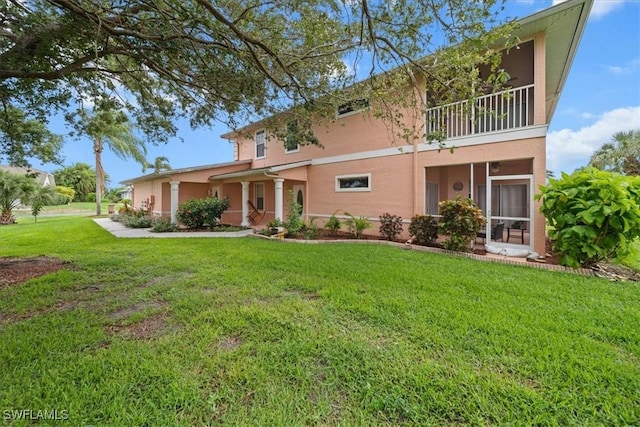 20025 Lake Vista Cir Unit 6B, Lehigh Acres, FL 33936 - view of front facade featuring stucco siding, a balcony, a front lawn, and a sunroom