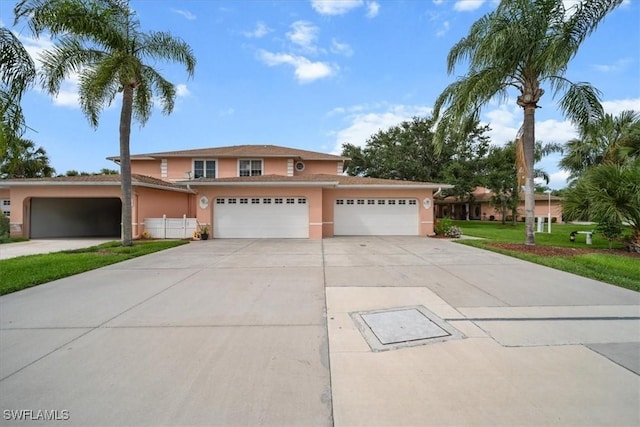 20025 Lake Vista Cir Unit 6B, Lehigh Acres, FL 33936 - traditional-style home with stucco siding, concrete driveway, a garage, and a front lawn