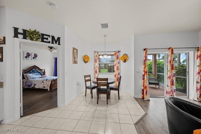 20025 Lake Vista Cir Unit 6B, Lehigh Acres, FL 33936 - dining area featuring a chandelier, healthy amount of natural light, and light wood finished floors