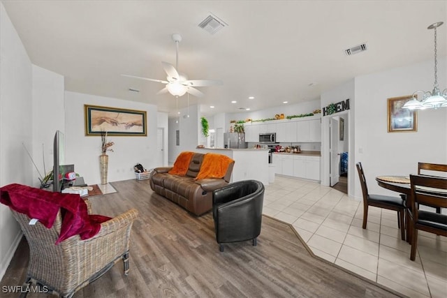 20025 Lake Vista Cir Unit 6B, Lehigh Acres, FL 33936 - living room with ceiling fan, light wood-type flooring, a chandelier, and baseboards