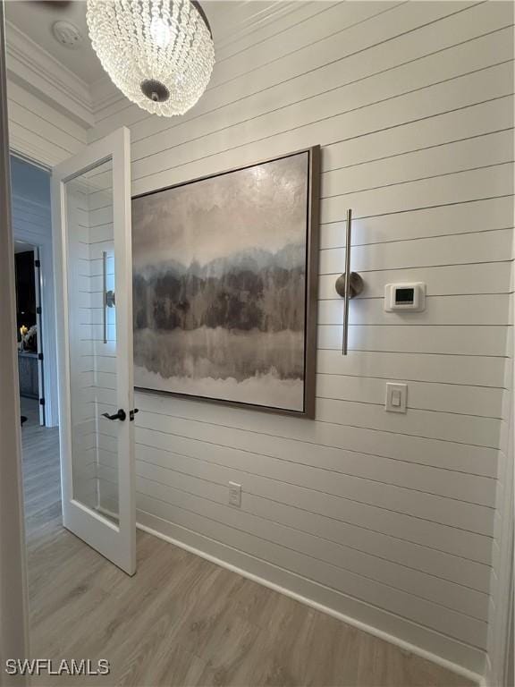 15108 Pescara St, Naples, FL 34114 - detailed view of wood finished floors, a chandelier, wooden walls, crown molding, and baseboards