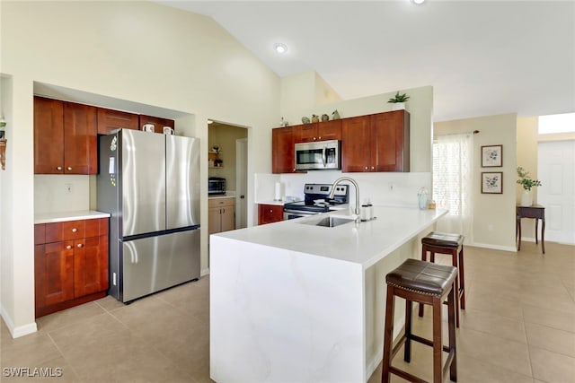 2223 SW 16th Ter, Cape Coral, FL 33991 - kitchen featuring stainless steel appliances, a breakfast bar area, a peninsula, light tile patterned floors, and high vaulted ceiling