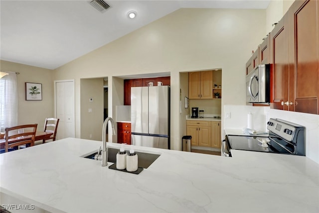 2223 SW 16th Ter, Cape Coral, FL 33991 - kitchen with appliances with stainless steel finishes, a sink, a peninsula, light stone counters, and high vaulted ceiling
