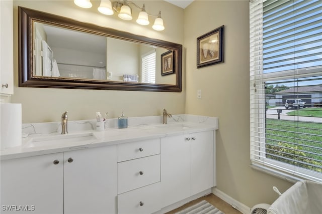 2223 SW 16th Ter, Cape Coral, FL 33991 - full bathroom featuring double vanity, plenty of natural light, and baseboards