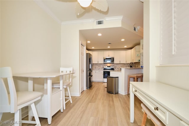 9110 Bayberry Bnd Unit 102, Fort Myers, FL 33908 - kitchen featuring appliances with stainless steel finishes, crown molding, white cabinets, backsplash, and light wood-style flooring