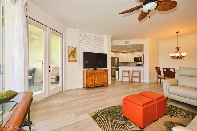9110 Bayberry Bnd Unit 102, Fort Myers, FL 33908 - living area with crown molding, light wood finished floors, a chandelier, a ceiling fan, and baseboards