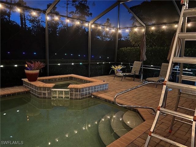 11010 Longwing Dr, Fort Myers, FL 33912 - pool at night with a patio area, glass enclosure, and a pool with connected hot tub