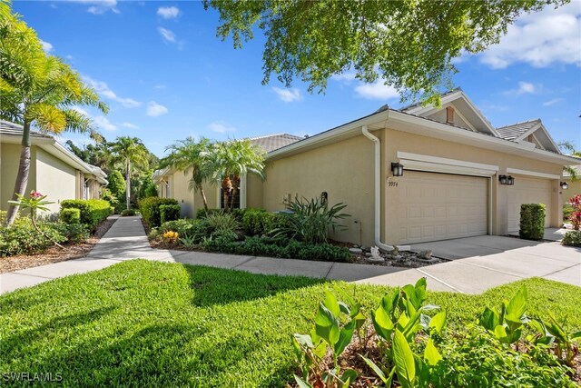 view of front of house with stucco siding, an attached garage, concrete driveway, and a front yard