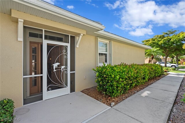 entrance to property with stucco siding