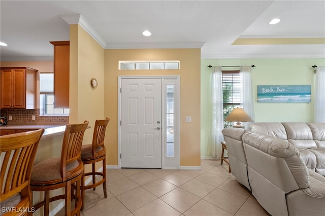 entryway with ornamental molding, recessed lighting, healthy amount of natural light, and light tile patterned floors