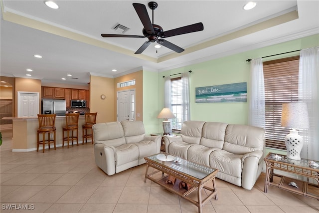 living room featuring a ceiling fan, crown molding, recessed lighting, light tile patterned floors, and a raised ceiling