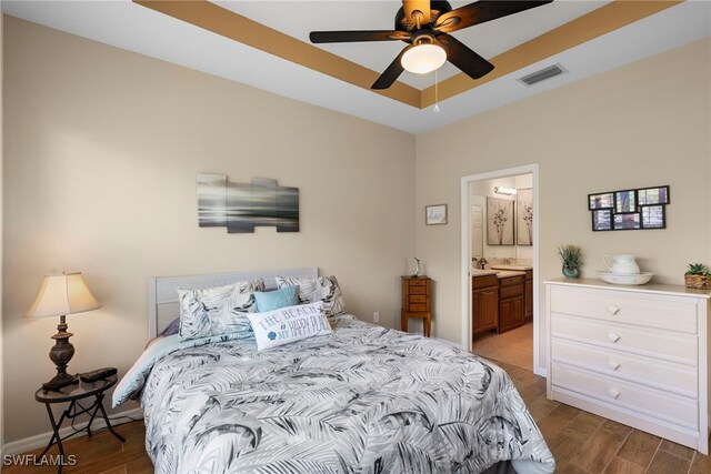 bedroom featuring wood finished floors, connected bathroom, and a ceiling fan