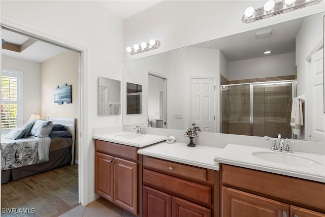 bathroom with double vanity, a shower stall, and ensuite bathroom