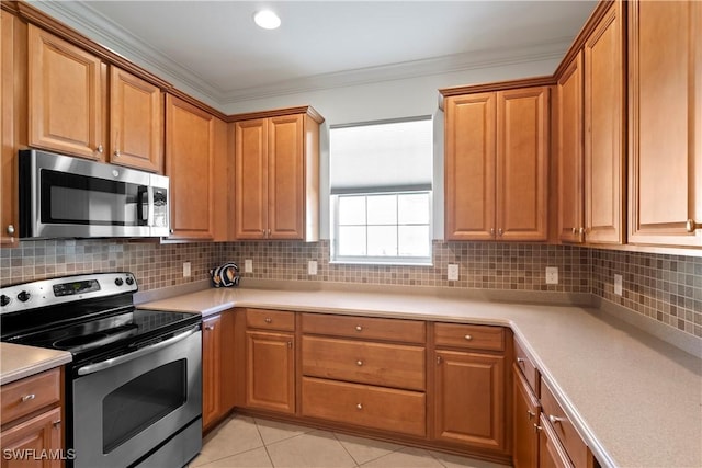kitchen with stainless steel appliances, decorative backsplash, light countertops, light tile patterned floors, and crown molding