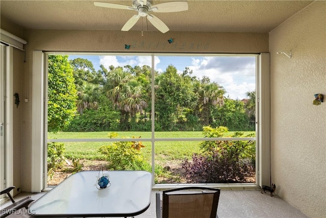 sunroom / solarium with view of wooded area