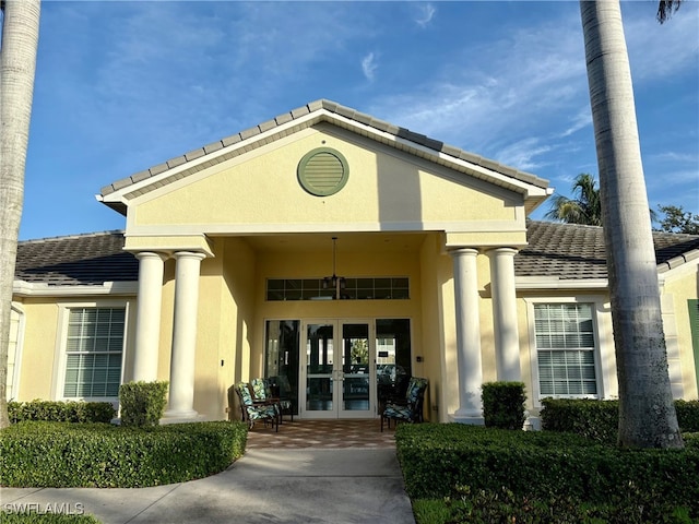 property entrance featuring french doors, stucco siding, and a tile roof
