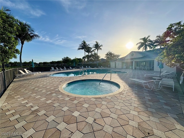 community pool with a patio and a hot tub