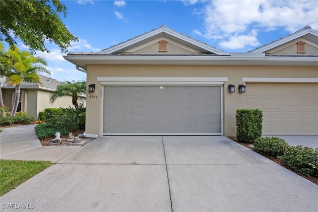 view of front of home with stucco siding, driveway, and an attached garage