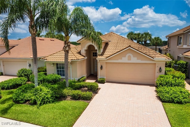 9211 Independence Way, Fort Myers, FL 33913 - mediterranean / spanish-style house featuring an attached garage, a tiled roof, stucco siding, and decorative driveway