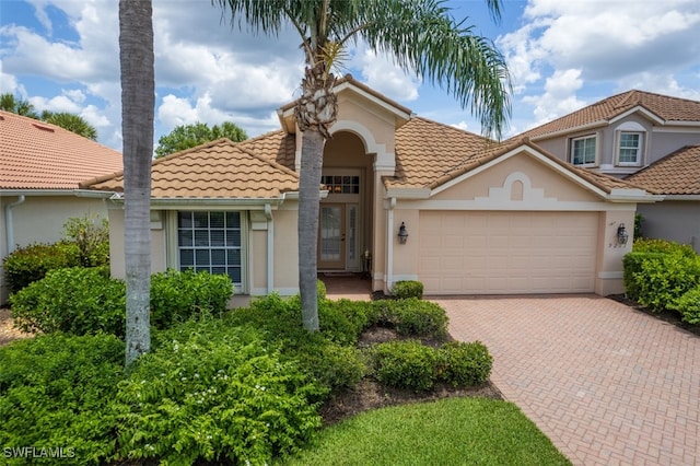 9211 Independence Way, Fort Myers, FL 33913 - mediterranean / spanish-style home with a garage, stucco siding, decorative driveway, and a tile roof
