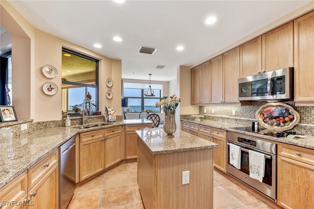 11600 Court Of Palms Unit 301, Fort Myers, FL 33908 - kitchen with appliances with stainless steel finishes, light brown cabinetry, a kitchen island, light stone countertops, and recessed lighting