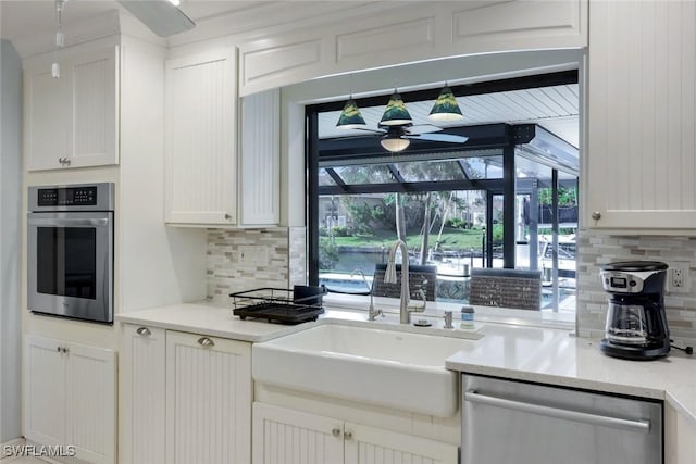 1528 SW 52nd Ln, Cape Coral, FL 33914 - kitchen with appliances with stainless steel finishes, a ceiling fan, a sink, and backsplash