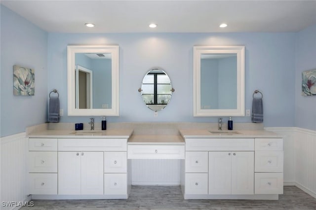 1528 SW 52nd Ln, Cape Coral, FL 33914 - bathroom featuring wainscoting, double vanity, and wood finished floors