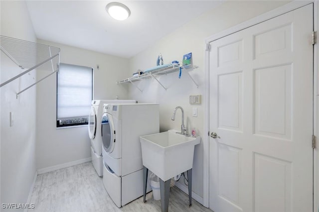 1528 SW 52nd Ln, Cape Coral, FL 33914 - laundry room with washing machine and clothes dryer, light wood finished floors, and baseboards