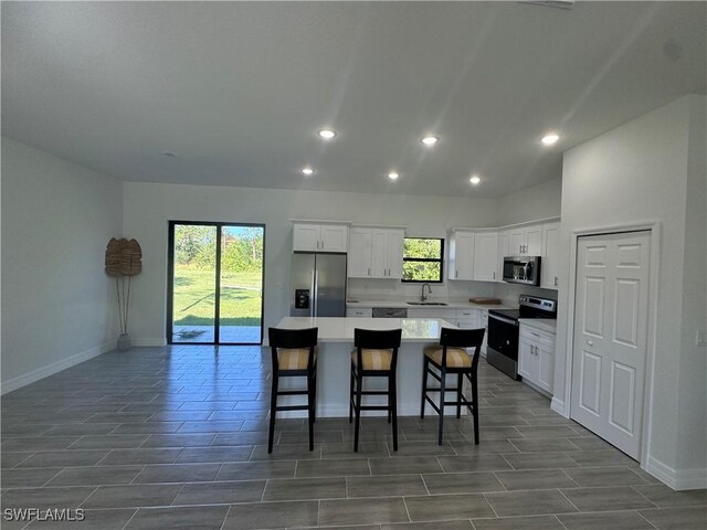 804 W 9th St, Lehigh Acres, FL 33972 - kitchen with appliances with stainless steel finishes, a center island, baseboards, healthy amount of natural light, and recessed lighting