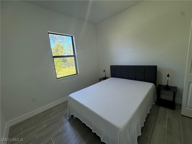 804 W 9th St, Lehigh Acres, FL 33972 - bedroom featuring baseboards and wood tiled floors