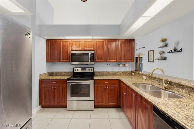 1226 SW 15th Ter, Cape Coral, FL 33991 - kitchen featuring appliances with stainless steel finishes, light stone countertops, light tile patterned floors, and a peninsula