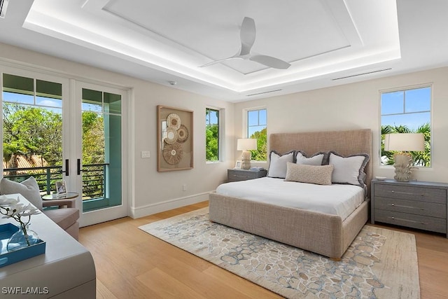 777 Broad Ct S, Naples, FL 34102 - bedroom with a tray ceiling, access to outside, and light wood-style flooring