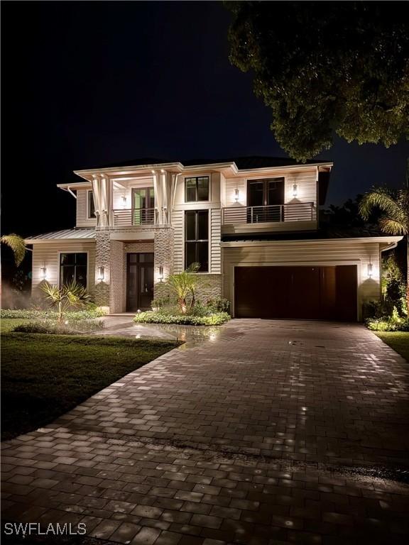 777 Broad Ct S, Naples, FL 34102 - view of front facade featuring a balcony, decorative driveway, an attached garage, and french doors