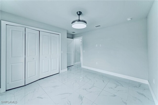 526 Wabasso Ave S, Lehigh Acres, FL 33974 - unfurnished bedroom featuring baseboards, light marble finish flooring, and a closet