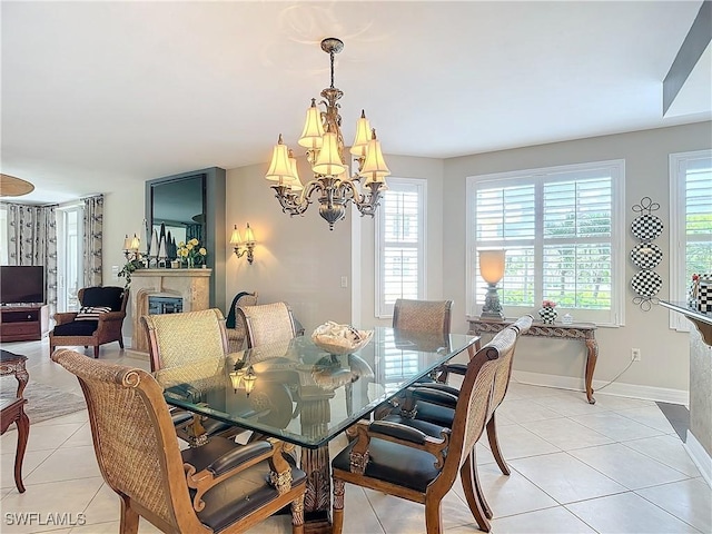 1131 Swallow Ave Unit 3-202, Marco Island, FL 34145 - dining room featuring light tile patterned flooring, a chandelier, and a glass covered fireplace