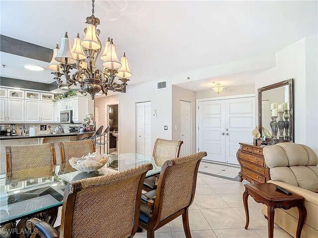1131 Swallow Ave Unit 3-202, Marco Island, FL 34145 - dining area featuring a chandelier and light tile patterned flooring