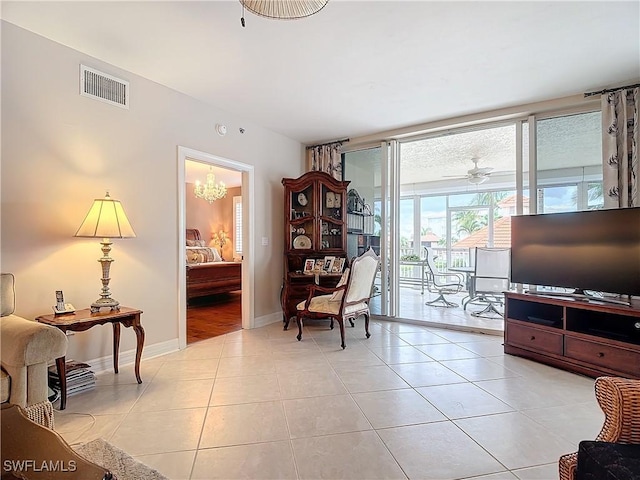 1131 Swallow Ave Unit 3-202, Marco Island, FL 34145 - living area with light tile patterned flooring, ceiling fan, and a chandelier