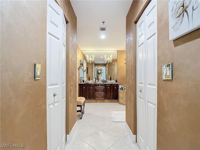 1131 Swallow Ave Unit 3-202, Marco Island, FL 34145 - hallway with a chandelier and light tile patterned floors