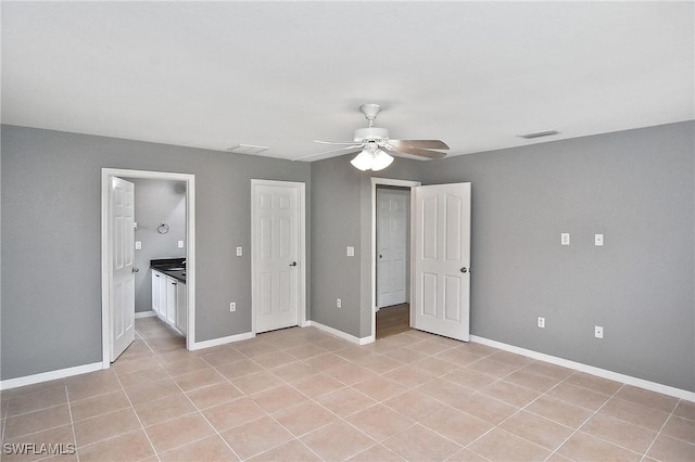 4016 35th St SW, Lehigh Acres, FL 33976 - unfurnished bedroom featuring a ceiling fan, light tile patterned flooring, baseboards, and ensuite bathroom