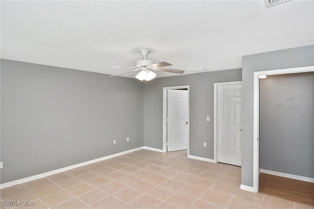 4016 35th St SW, Lehigh Acres, FL 33976 - unfurnished bedroom featuring baseboards, a ceiling fan, and light tile patterned floors