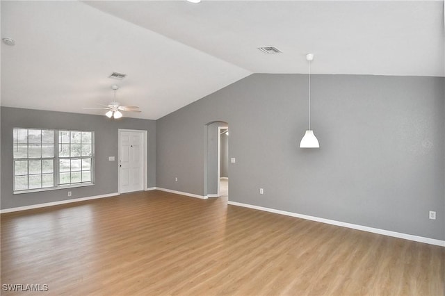 4016 35th St SW, Lehigh Acres, FL 33976 - unfurnished living room with wood finished floors, vaulted ceiling, arched walkways, ceiling fan, and baseboards
