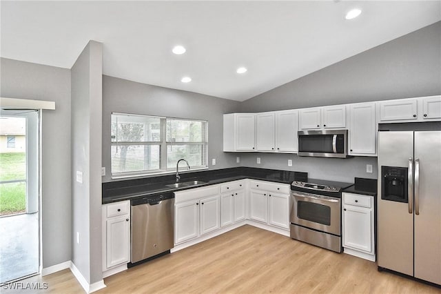 4016 35th St SW, Lehigh Acres, FL 33976 - kitchen featuring appliances with stainless steel finishes, a sink, lofted ceiling, white cabinetry, and light wood-style floors