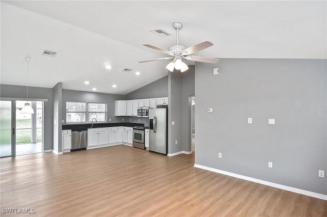 4016 35th St SW, Lehigh Acres, FL 33976 - kitchen with stainless steel appliances, ceiling fan, baseboards, white cabinets, and high vaulted ceiling