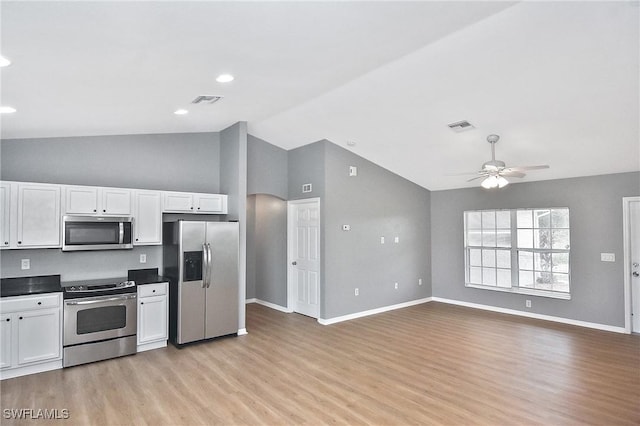 4016 35th St SW, Lehigh Acres, FL 33976 - kitchen featuring stainless steel appliances, white cabinets, light wood finished floors, baseboards, and dark countertops