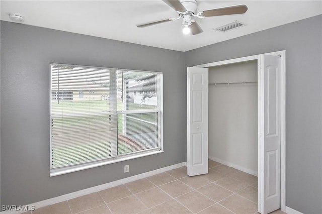 4016 35th St SW, Lehigh Acres, FL 33976 - unfurnished bedroom with light tile patterned floors, a closet, baseboards, and a ceiling fan