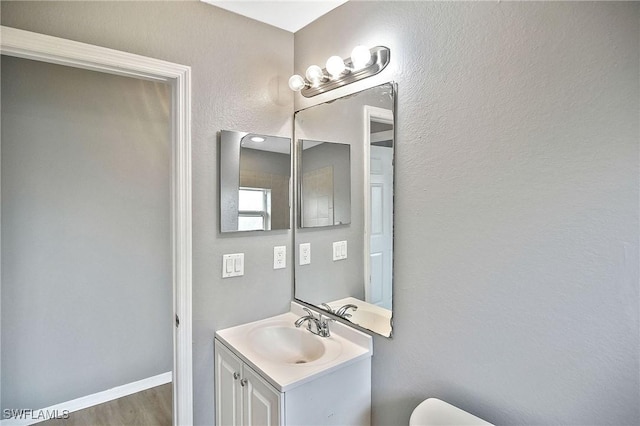 4016 35th St SW, Lehigh Acres, FL 33976 - half bathroom with vanity, wood finished floors, toilet, and baseboards